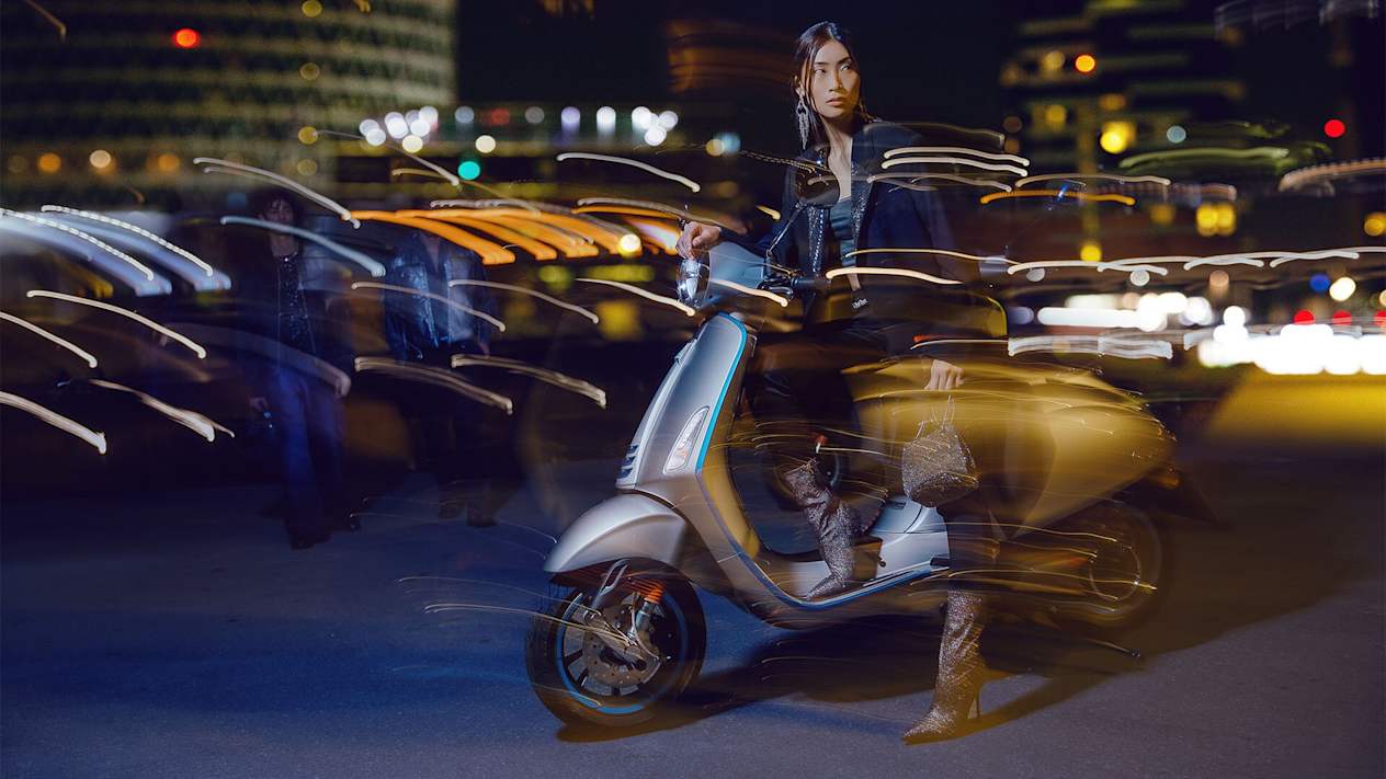 Scooter Vespa Elettrica vue trois quarts avant gauche avec modèle