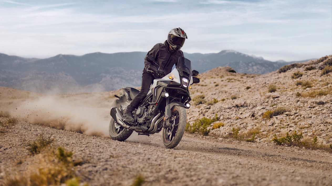 Honda NX500 2024 : trois quarts avant droit sur piste de graviers