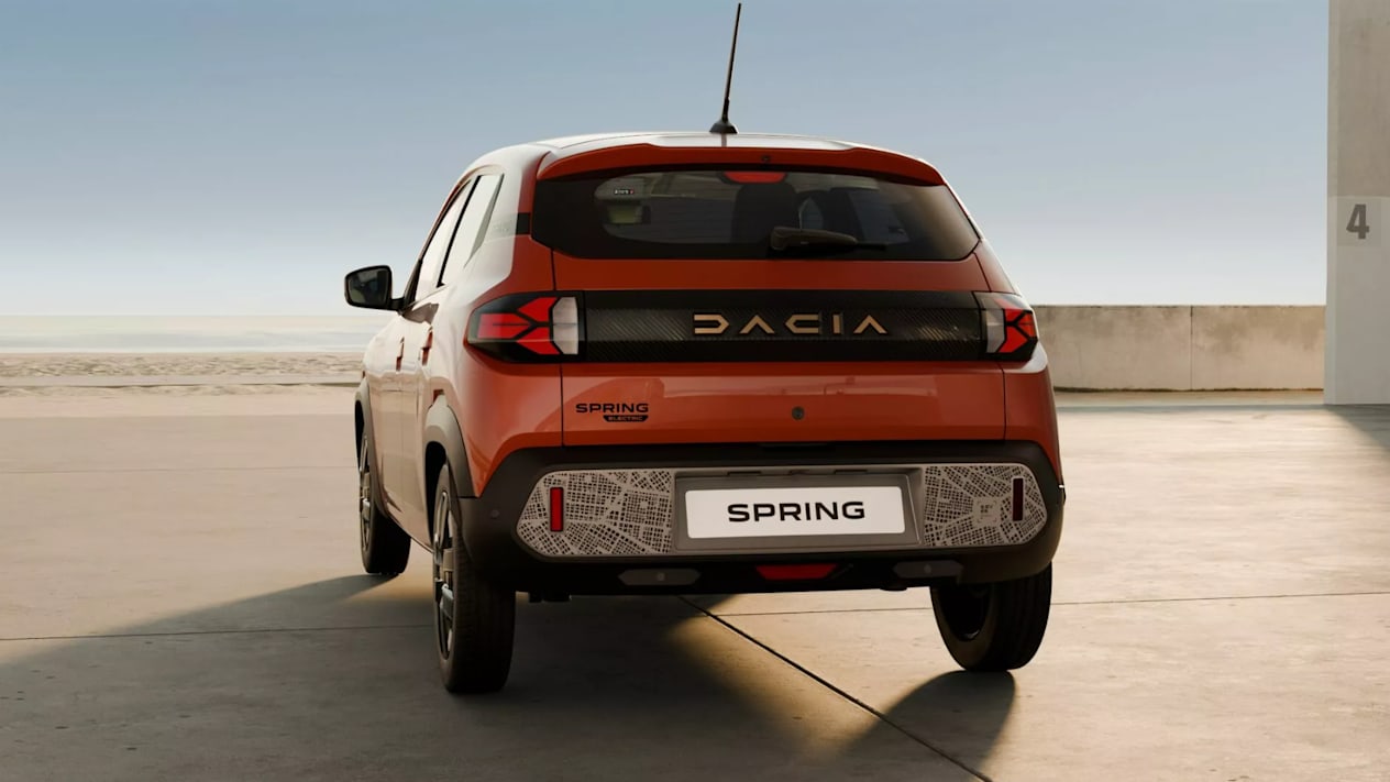 Rear view of an orange Dacia Spring showing the new bumper decal