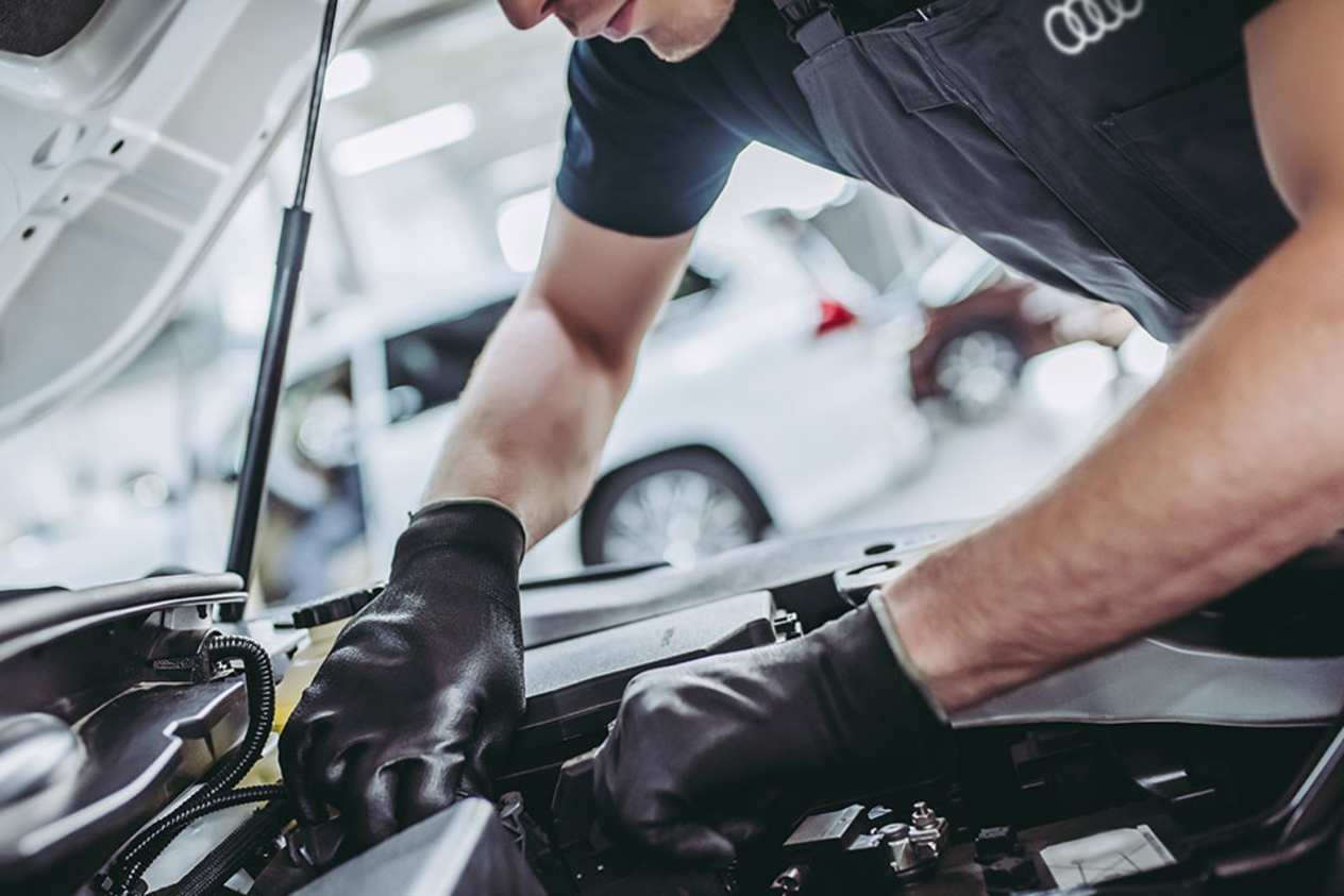 Audi mechanic in the bonnet of a car