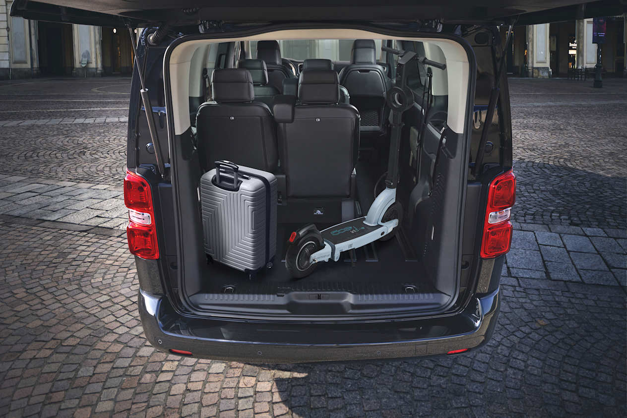 Fiat e-Ulysse : Coffre ouverte avec un siège rabattus avec une valise et une trotinette électrique