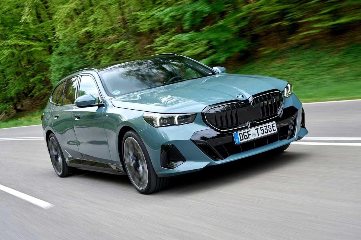 bmw i5 touring driving through woods