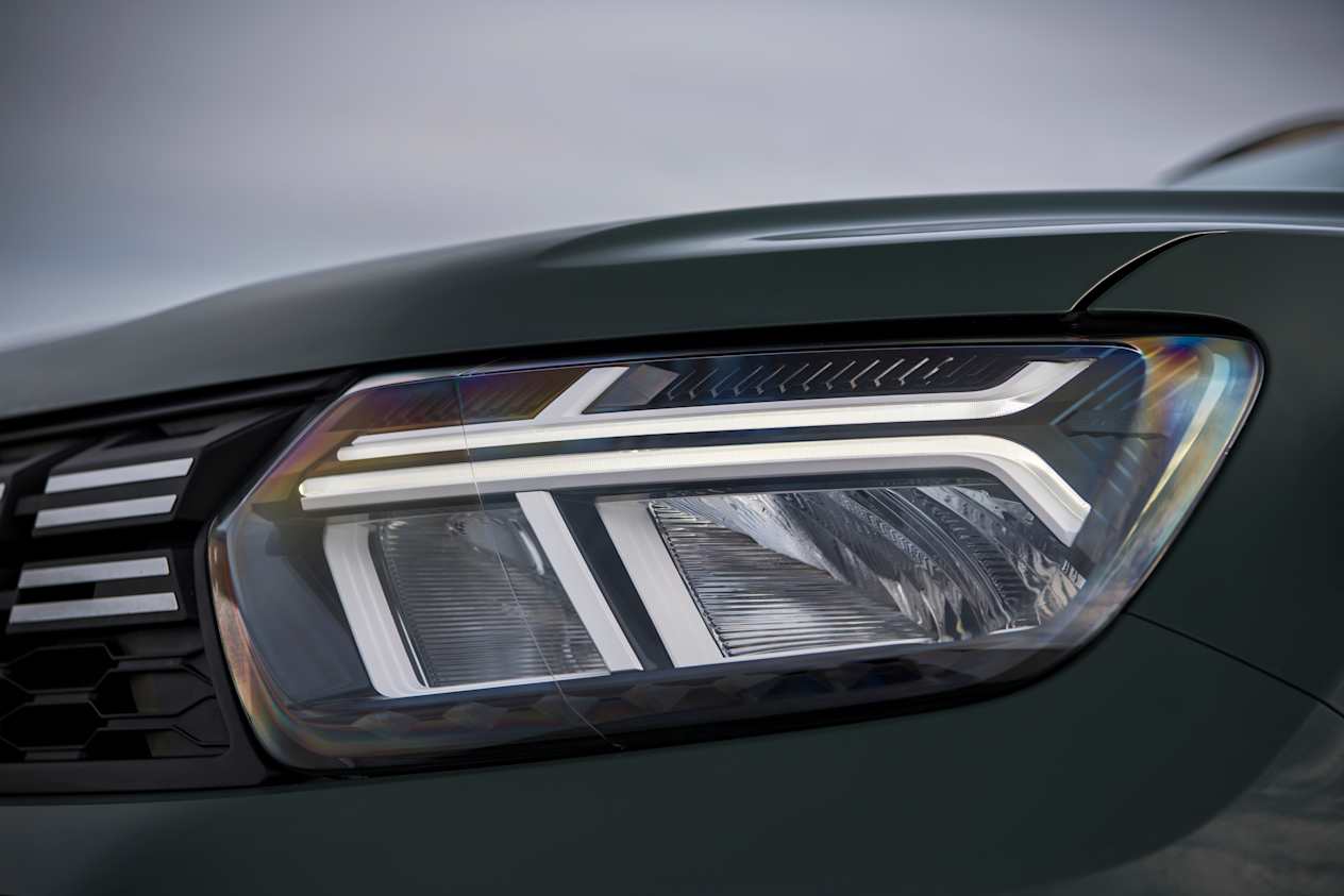 CLose up of the headlight on a green Dacia Duster