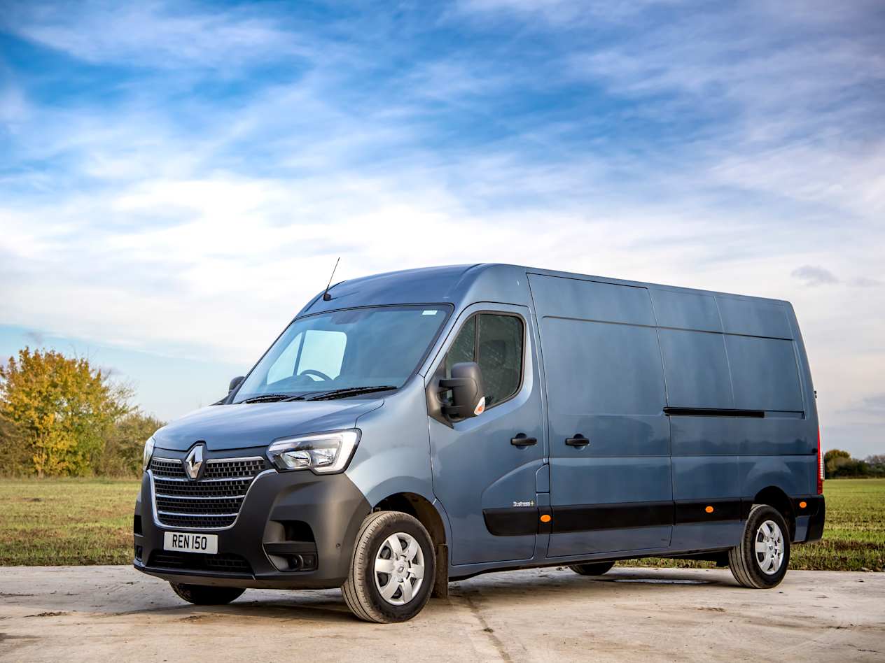 A blue Renault Master parked in an open grassy area