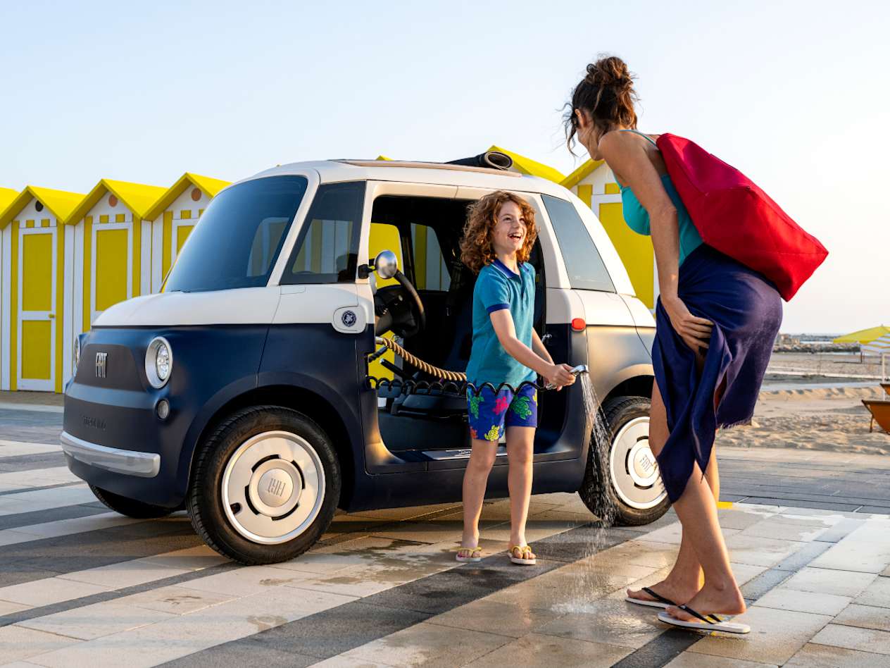 Fiat Topolino Vilebrequin 2025 : trois quarts avant gauche statique en bord de plage avec enfant et sa mère