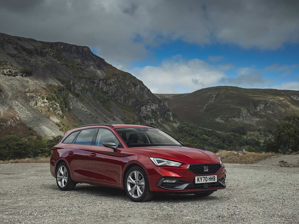 A red Sea Leon Estate parked in a rocky area in front of some hills