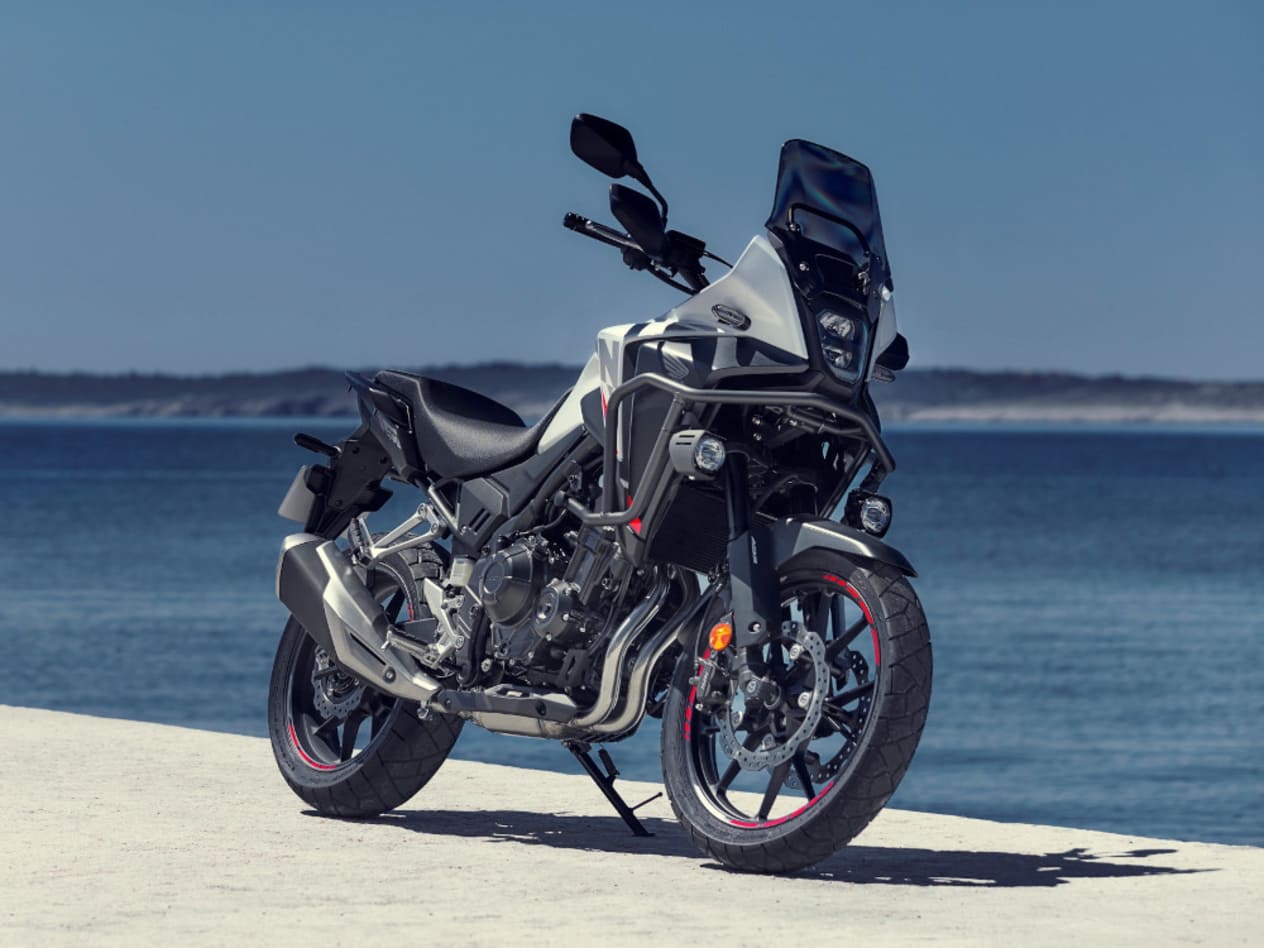 Honda NX500 2024 : trois quarts avant droit statique en bord de mer