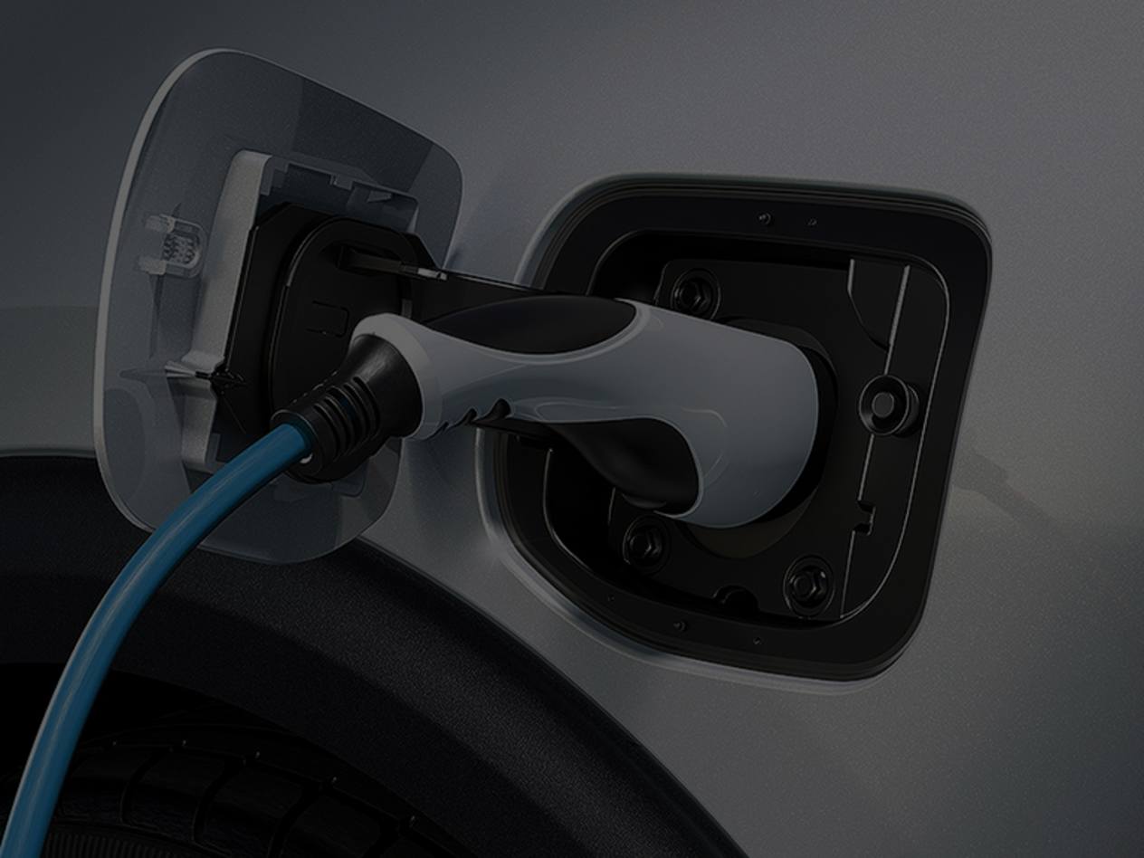 Electric vehicle charging cable plugged into white car