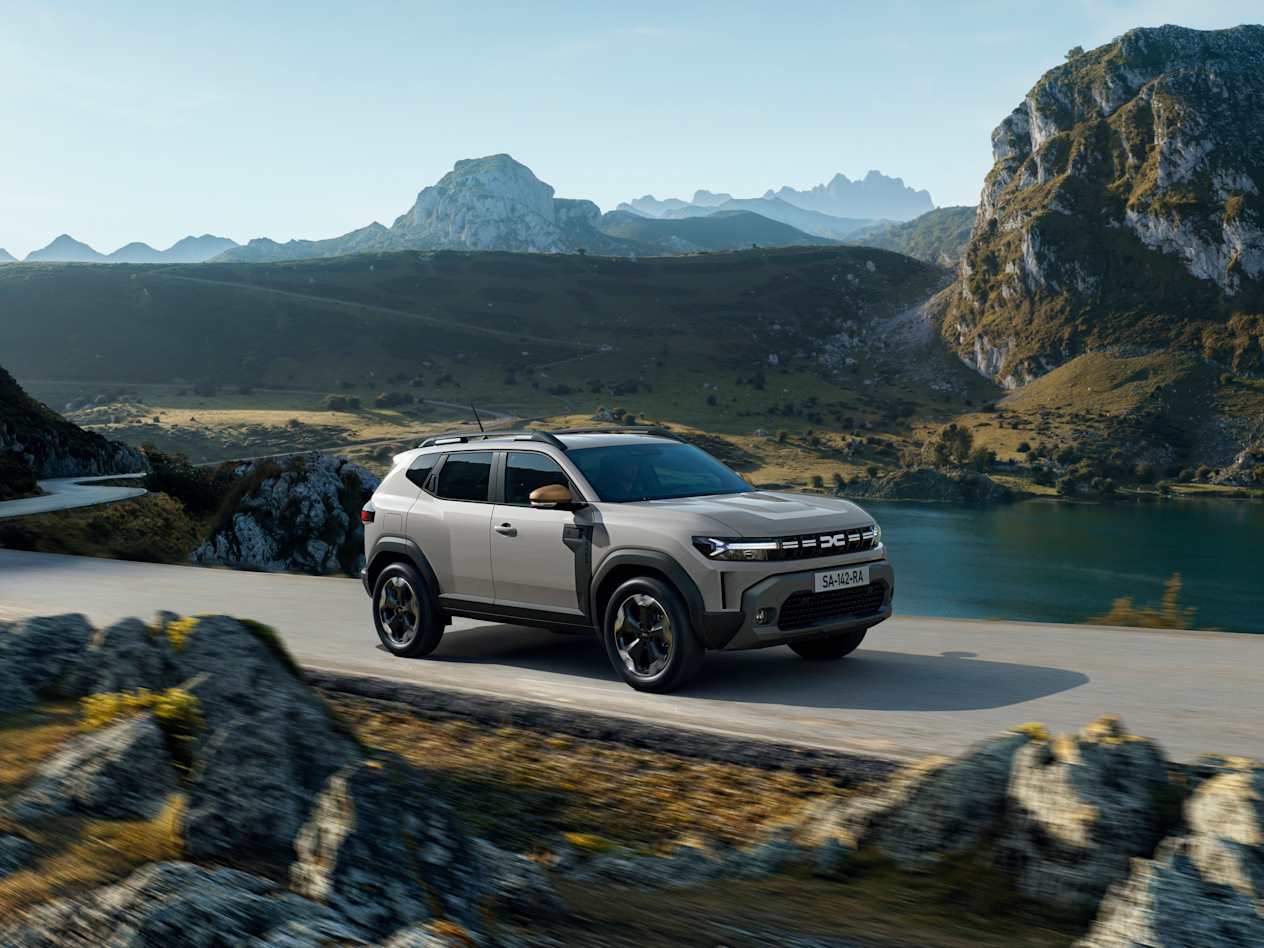 Grey All-New Dacia Duster driving through a rugged landscape
