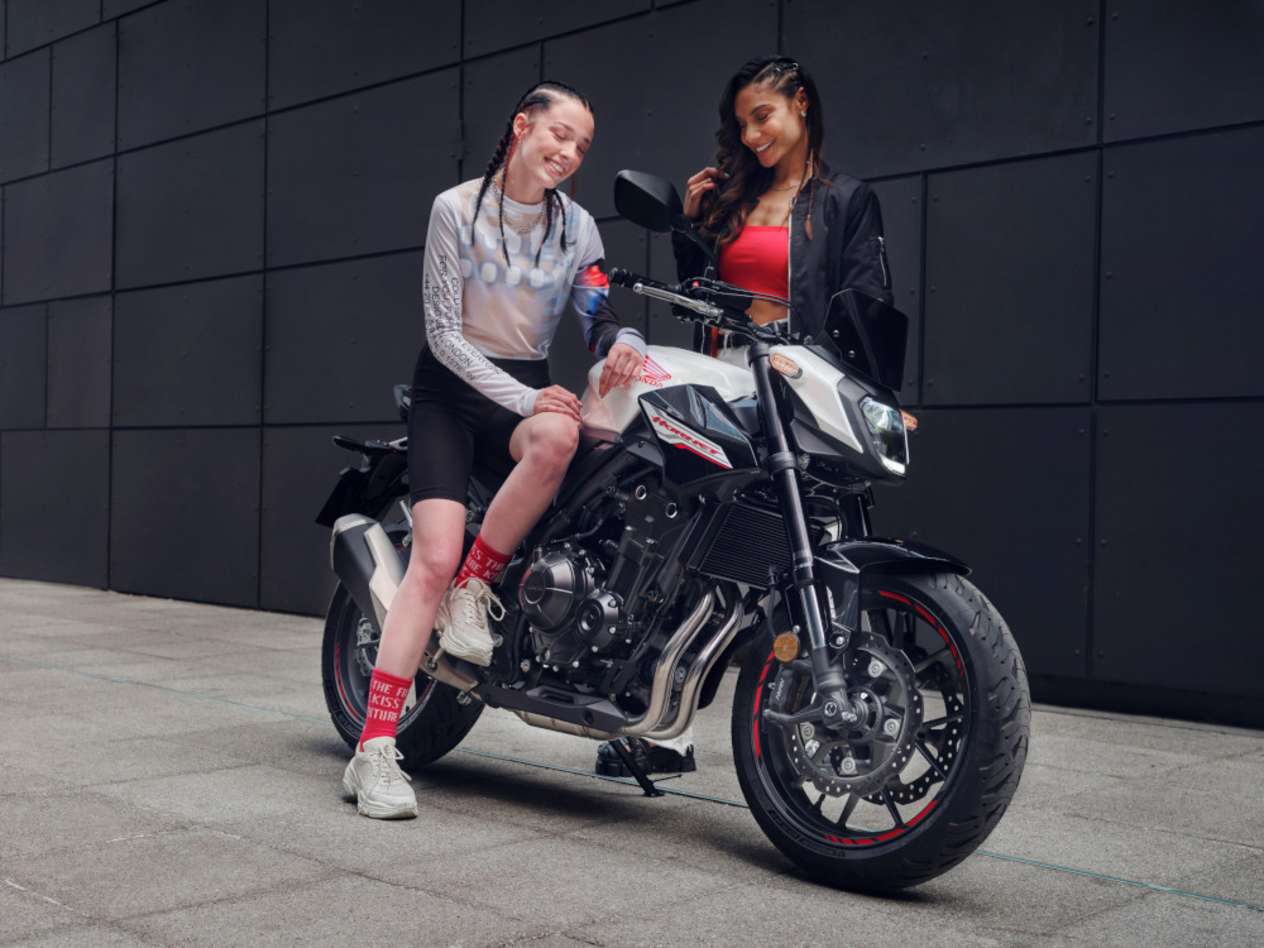 Honda CB500 Hornet 2024 : trois quarts avant droit statique avec jeunes filles