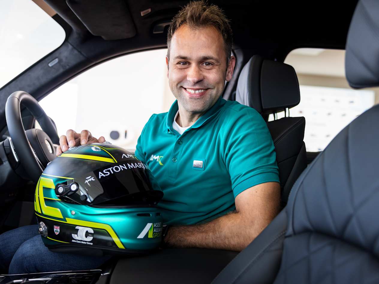 Jonny Adam sat inside a car with his Aston Martin helmet