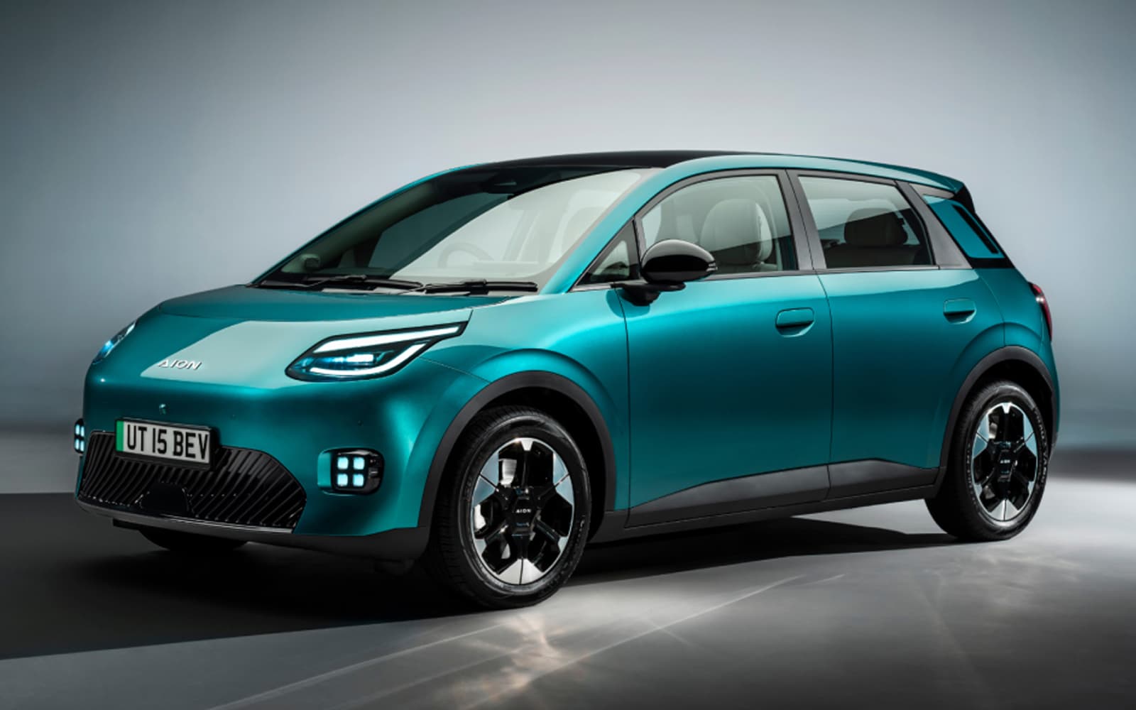 Teal AION UT electric hatchback in a studio