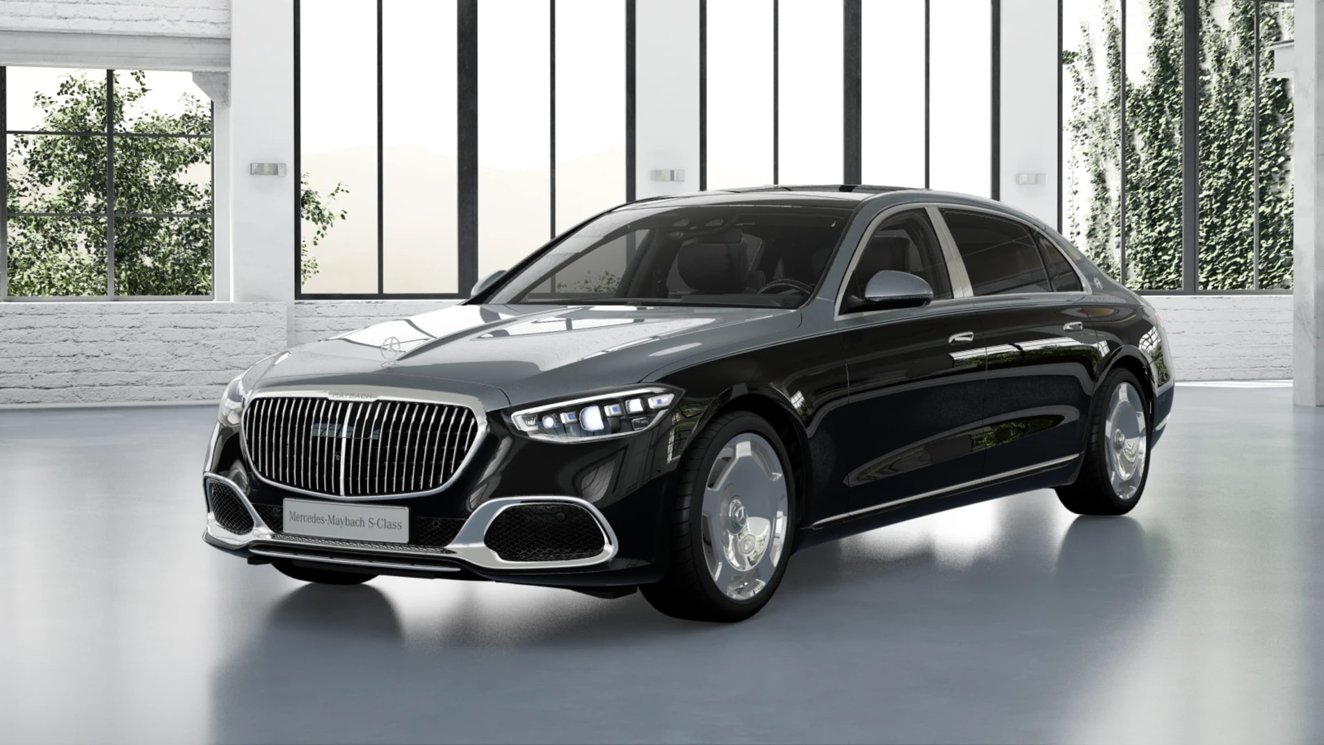 Black Mercedes-Maybach S 580 sedan inside a glass-walled industrial showroom