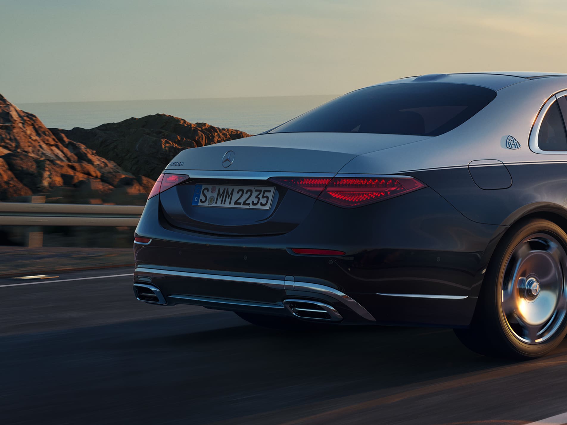 Dark Mercedes-Maybach S-Class driving on a mountain road at dusk