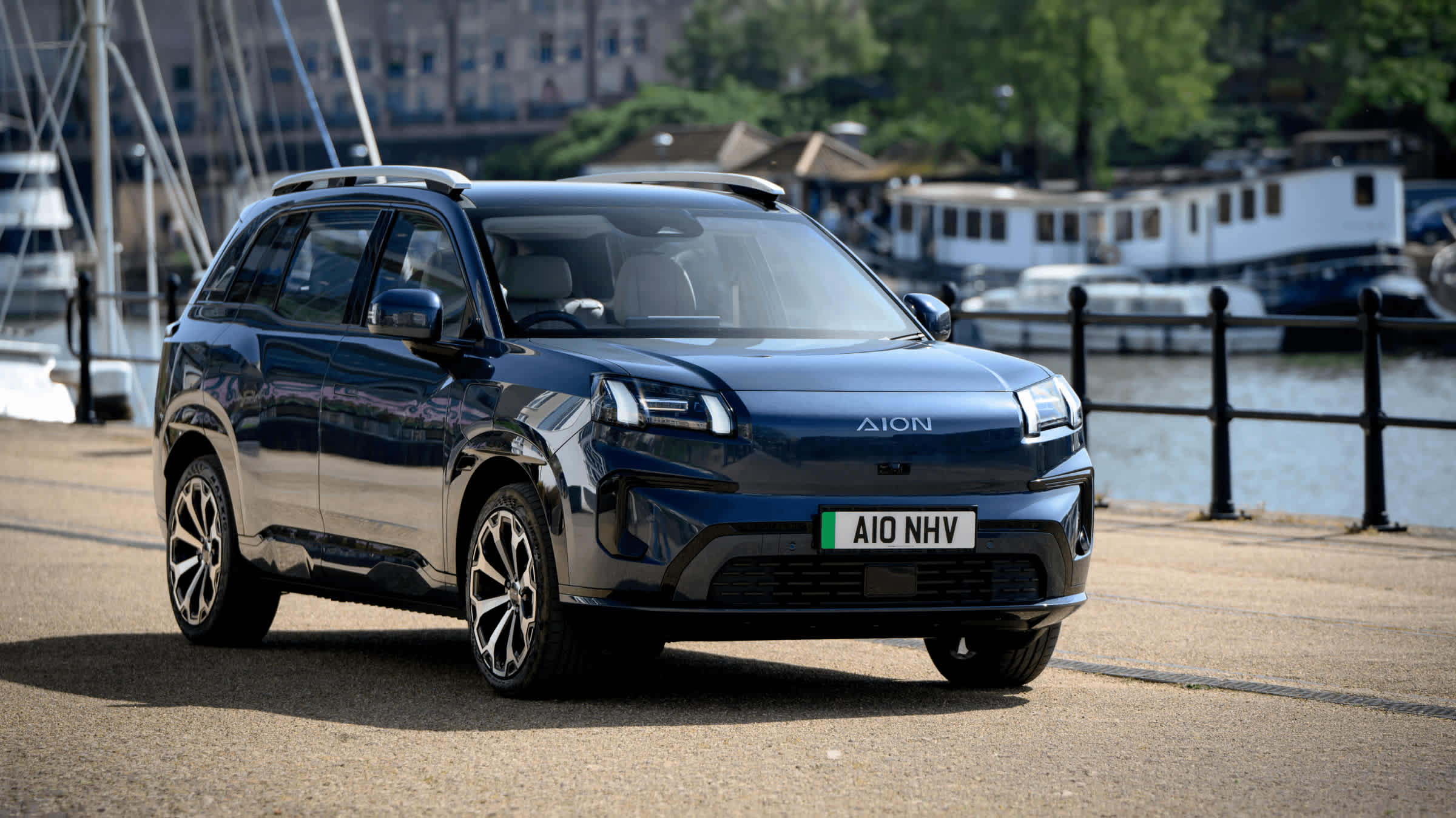 Blue AION V electric SUV beside a marina