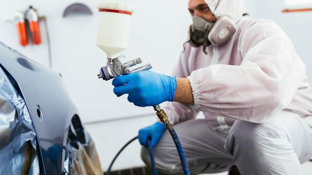 Volkswagen trained bodyshop technician refinishing paintwork with approved paint
