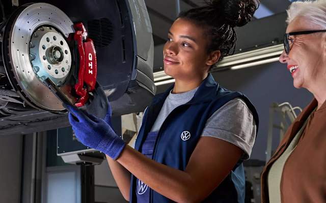 Volkswagen technician pointing out a brake to a customer – brake checks at Camerons Volkswagen, Perth