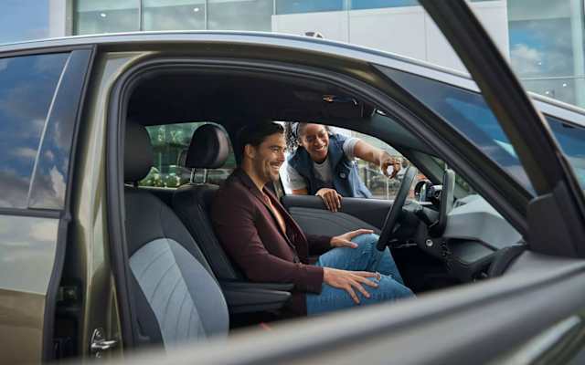 Volkswagen service adviser talking to an ID. driver through the window about software updates – Camerons Volkswagen, Perth