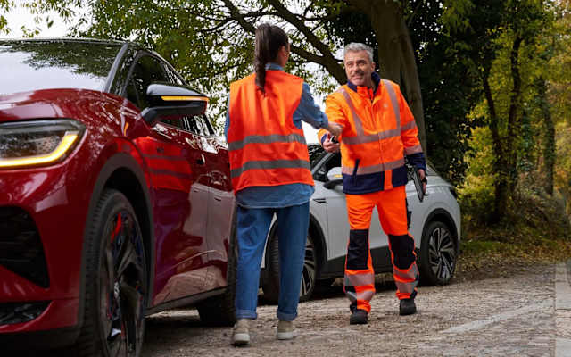 Volkswagen Roadside Assistance technician helping a driver beside two ID. models – Camerons Volkswagen, Perth