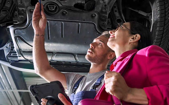 Volkswagen technician inspecting the underside of a car on a ramp – engine and chassis repairs at Camerons Volkswagen, Perth