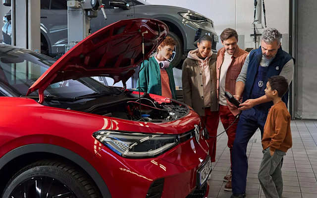 Volkswagen technician showing a family a battery check on a tablet – battery replacement at Camerons Volkswagen, Perth