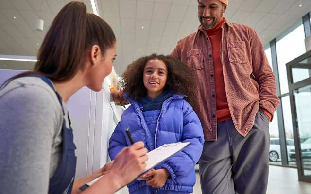 Father and daughter with a Volkswagen service expert – warranty work at Camerons Volkswagen, Perth
