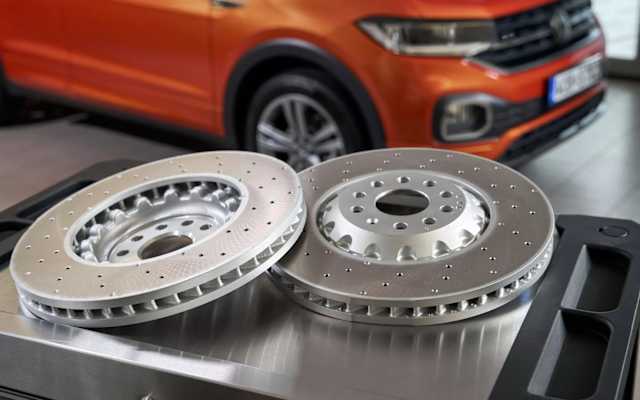 Two Volkswagen Genuine brake discs on a workshop bench – repairs and genuine parts at Camerons Volkswagen, Perth