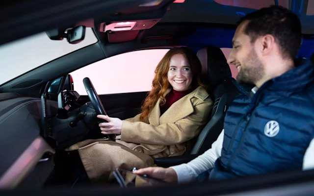 Smiling driver in a Volkswagen with a Camerons adviser in the passenger seat – part exchange and valuations at Camerons Volkswagen, Perth