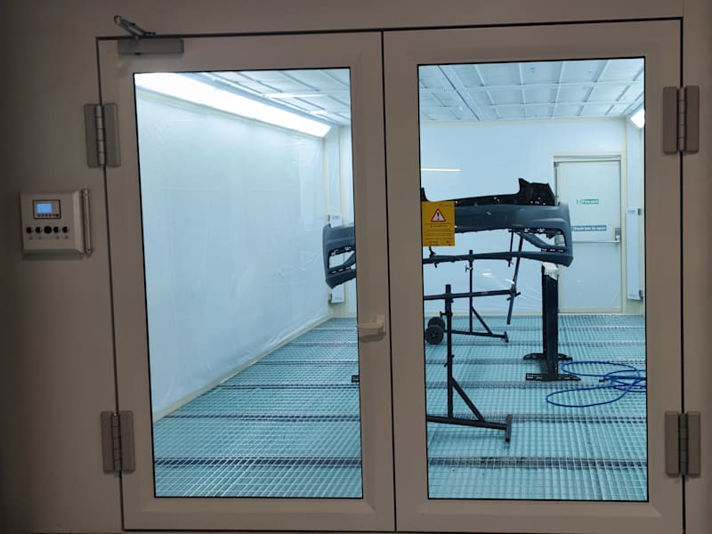 Bodyshop spray booth with a bumper prepared for refinishing