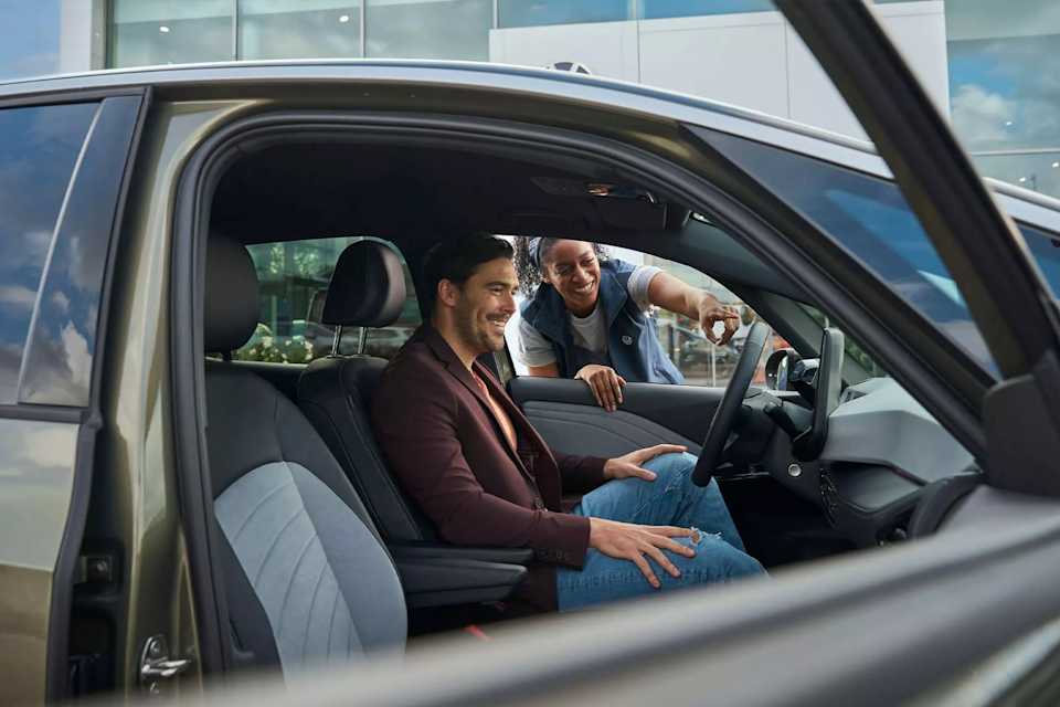 Volkswagen service adviser talking to an ID. driver through the window about software updates – Camerons Volkswagen, Perth