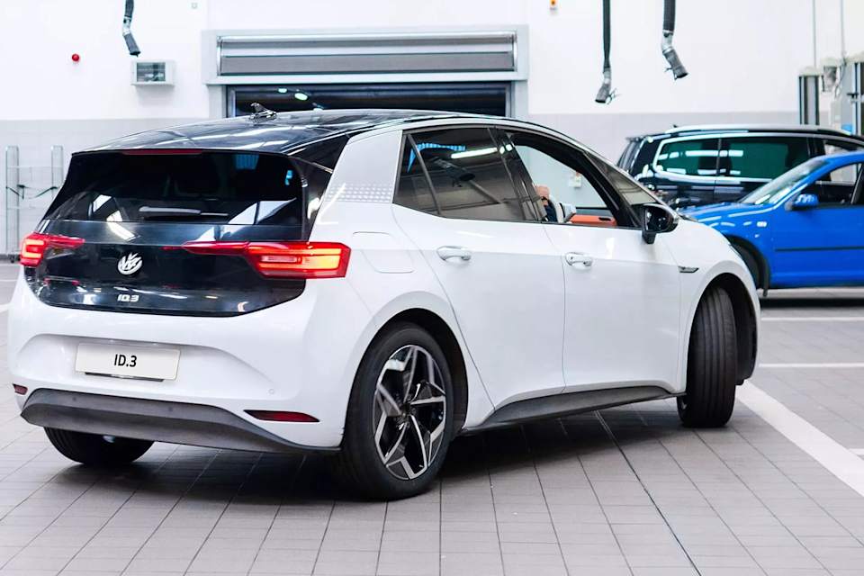 Woman standing beside a Volkswagen ID.4 holding her phone – electric battery warranty at Camerons Volkswagen, Perth