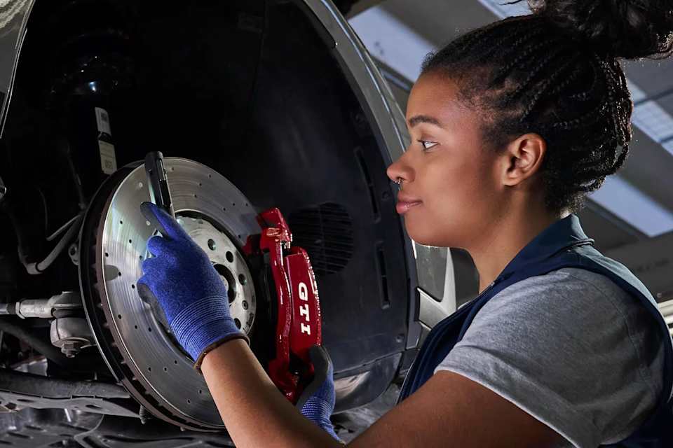 Volkswagen technician fitting a brake pad – genuine parts fitted by experts at Camerons Volkswagen, Perth