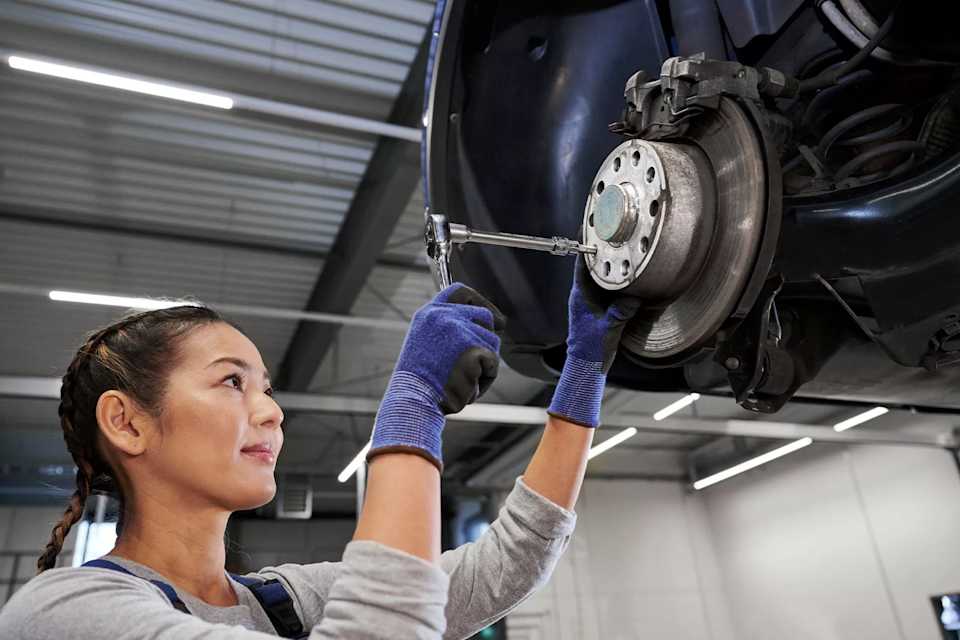 Volkswagen technician checking the brakes of a car on a ramp – brake service at Camerons Volkswagen, Perth