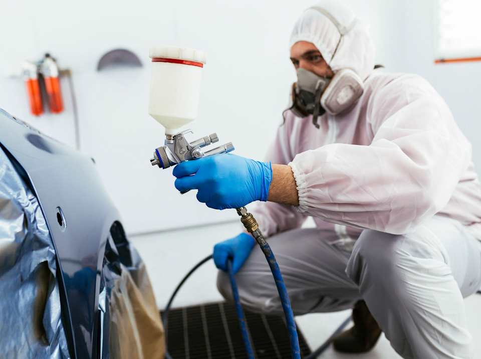 Volkswagen trained bodyshop technician refinishing paintwork with approved paint